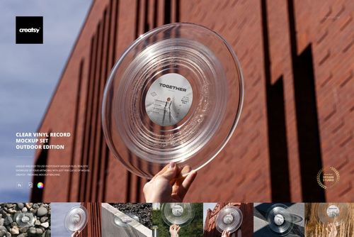 Close-up of a transparent vinyl record mockup being held up outside against a modern brick wall background.
