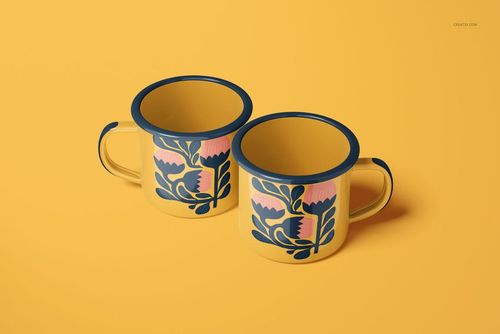 PSD mockup of two enamel mugs with stylized floral motifs in navy and pink, arranged side by side on yellow.