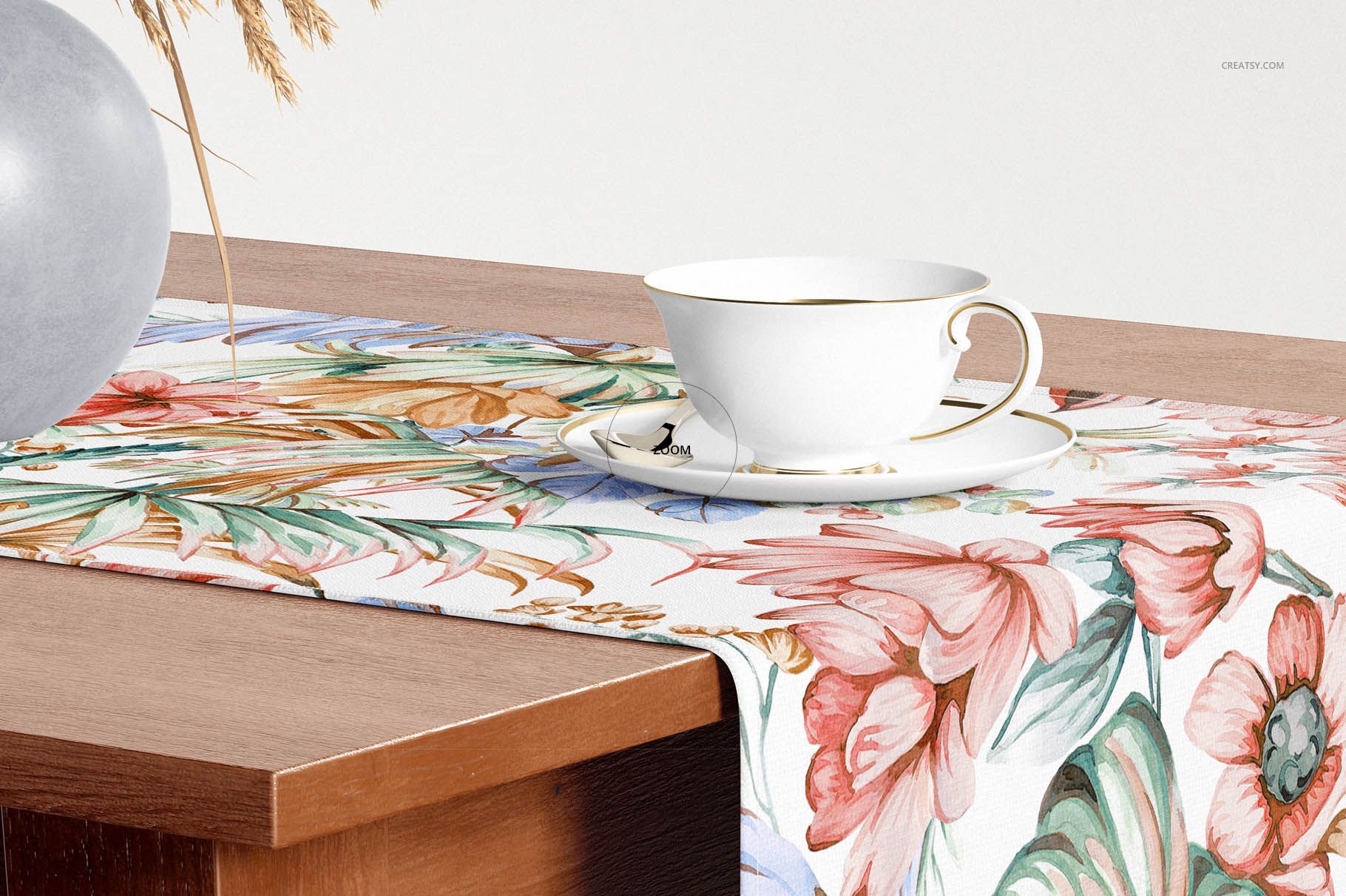 Colorful botanical table runner mockup draped over a wood table, featuring a cup and saucer and decorative vase.