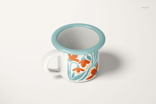 Enamel mug with a teal rim and floral orange and teal pattern, shown in a front angled view on a light background.
