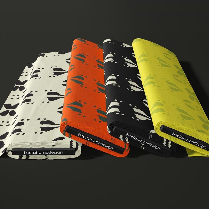 Fabric bolts mockup showing four stacked bolts with abstract spot patterns in white, orange, black, and yellow colors.