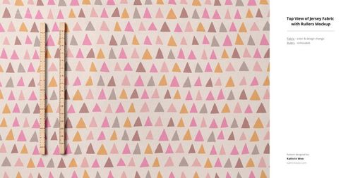 Jersey fabric mockup displaying a geometric triangle print in warm colors, viewed from above with rulers for scale.