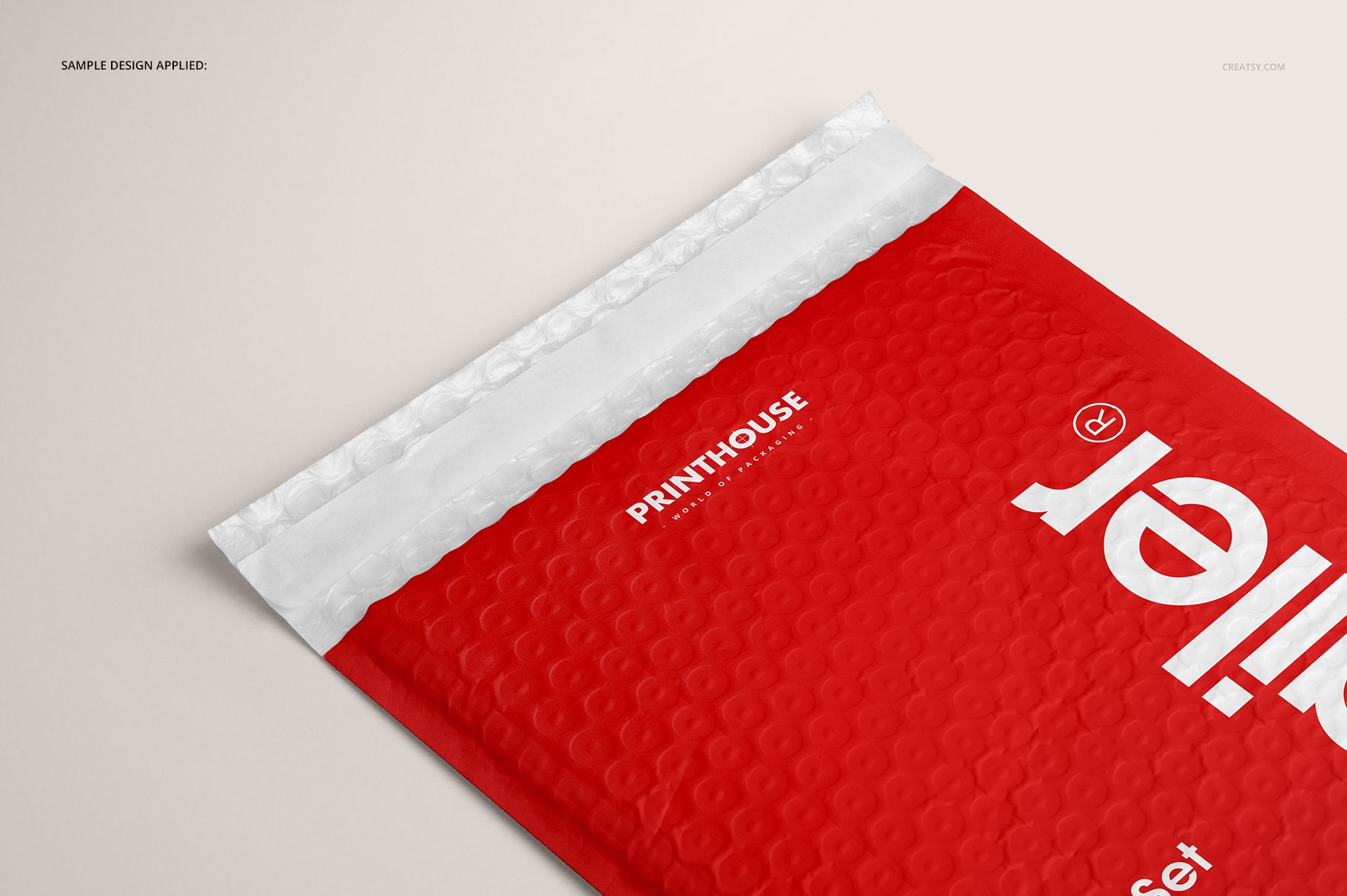 Red bubble mailer packaging mockup shown from a top angle, featuring a white sealing strip and subtle circular texture.