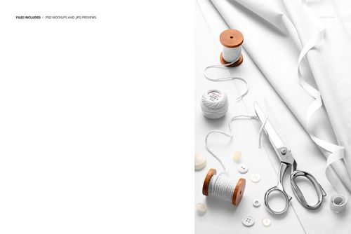 Top view of white cotton fabric mockup with sewing tools, including scissors, thread spools, and buttons on a white background.