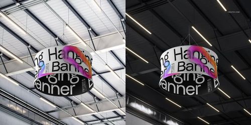 Round advertising banner mockup featuring prominent typography and vibrant graphic elements, viewed from below inside a spacious industrial hall.