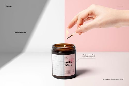Amber jar candle mockup with a hand lighting the wick using a match, shown on a split white and pink background.