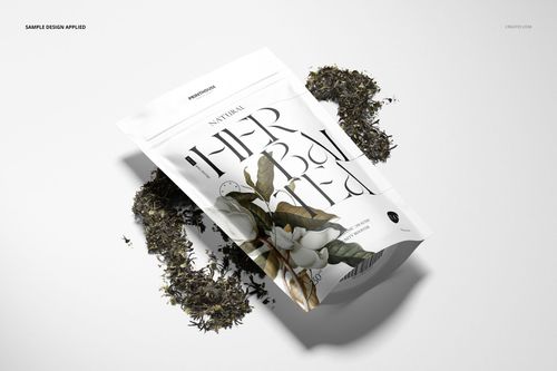 Mockup of a stand up zip lock bag featuring floral design, shown in perspective view with tea leaves scattered around.