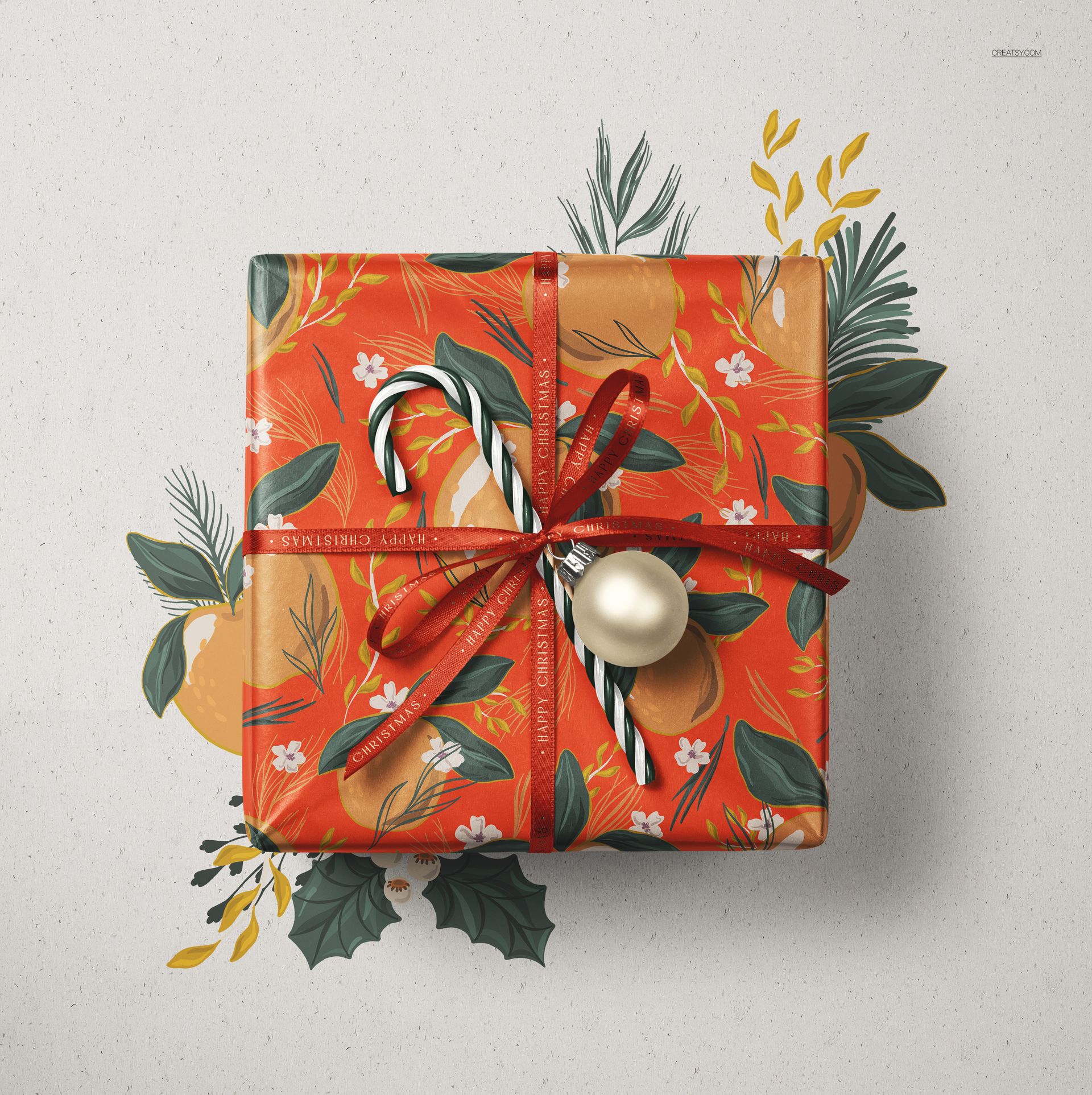 Christmas-themed wrapped gift box mockup featuring a red ribbon, festive foliage, candy cane, and ornament, top perspective.