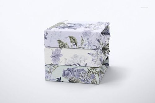 Brushed cotton sheet mockup set displaying a pile of floral patterned bedding, photographed against a light neutral backdrop.