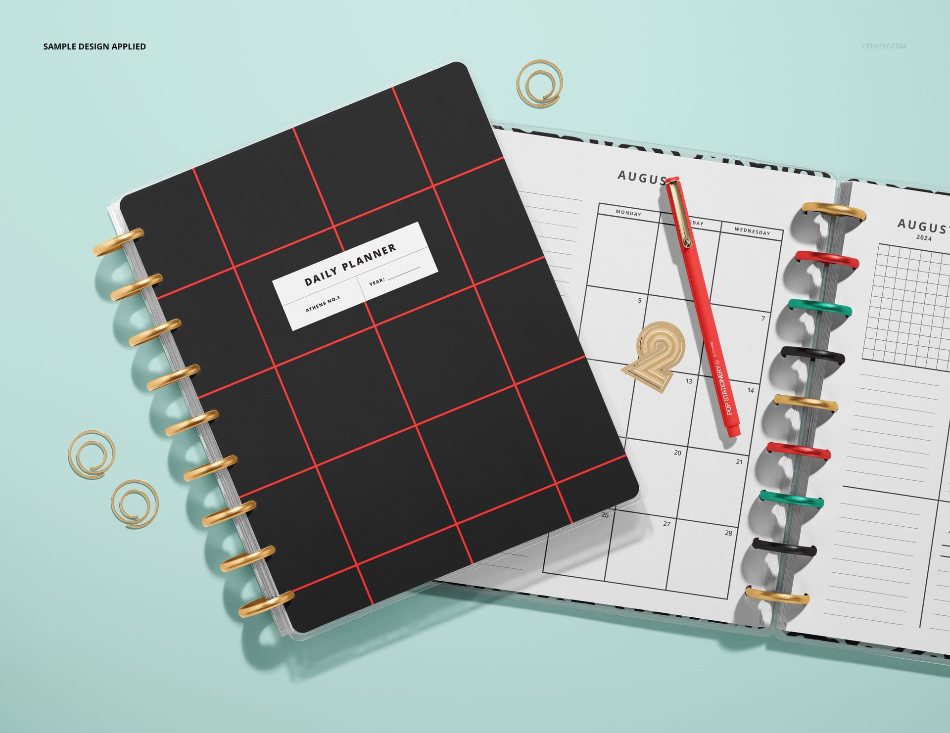 Top view PSD mockup showing two spiral planners, one closed with a patterned cover and one open with monthly sheets.