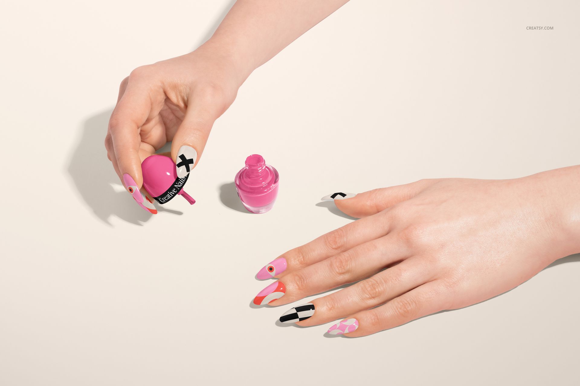 PSD mockup featuring a top view of a hand with artistic nail art and a pink nail polish container on a neutral surface.