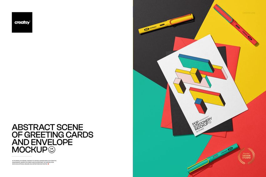 Abstract scene featuring greeting cards and an envelope mockup on colorful paper backgrounds with pens arranged nearby.