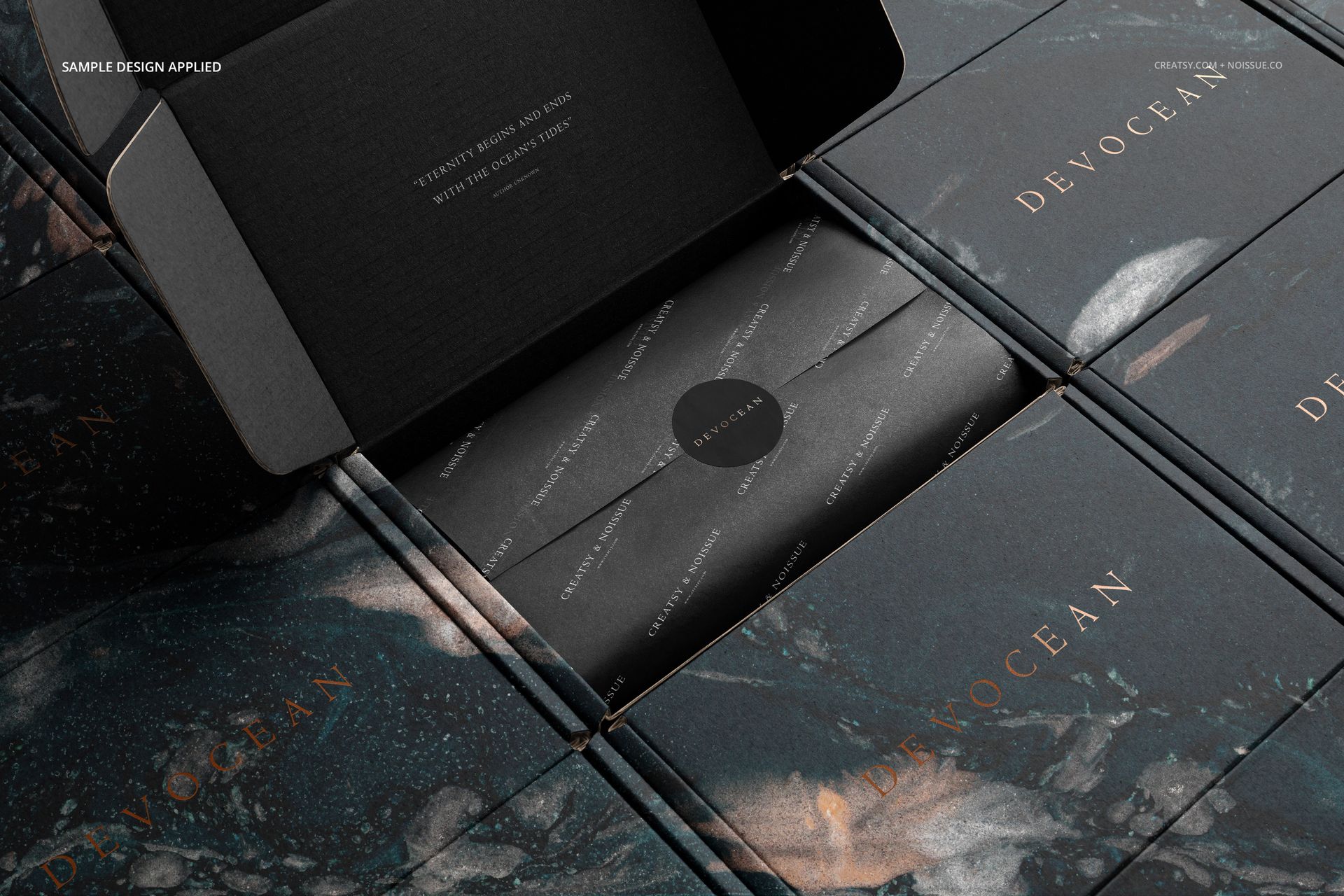 Close-up of Noissue mailing box mockup set with black and blue marbled design, gold lettering, and inner packaging details.