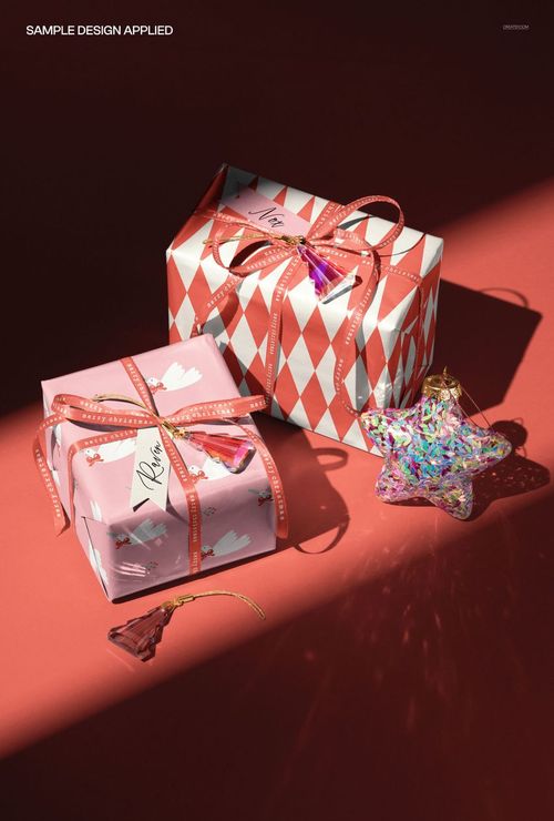 Christmas decor mockup featuring two wrapped presents in pink and red patterns, with ribbon and holiday ornaments.