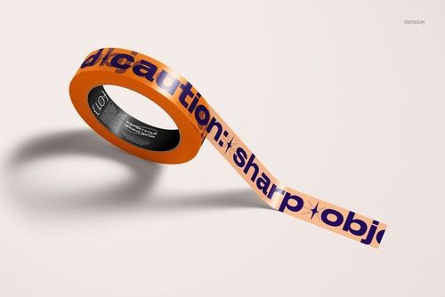 PSD mockup of a narrow, semi-transparent duct tape with orange and blue caution text, angled on a plain surface.
