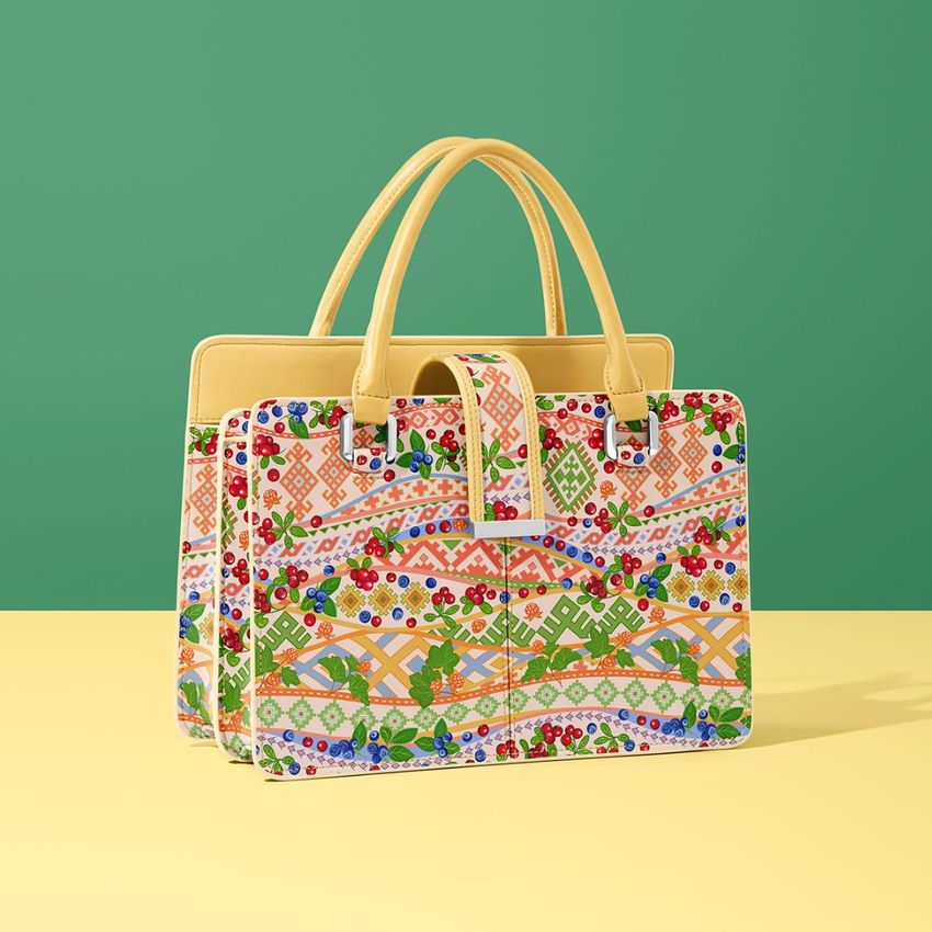 Leather handbag mockup featuring a structured bag with dual handles, decorated in colorful geometric and floral patterns on a yellow surface.