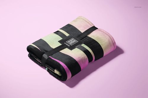 Fleece blanket mockup featuring horizontal black, green, and pink stripes, folded and tied with a black label.
