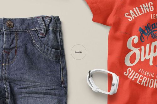 Front view of a baby t-shirt mockup in bright orange with white printed text, next to denim jeans and a white wristband.