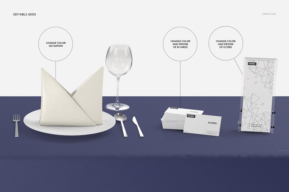 Table setting featuring a dark blue tablecloth mockup, white napkin on a plate, glassware, and customizable cards.
