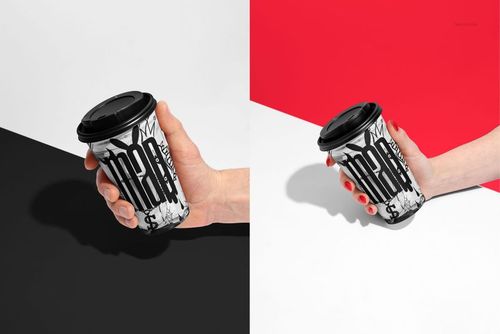 Paper coffee cup mockup in hand, featuring abstract black and white pattern, displayed on contrasting color surfaces.