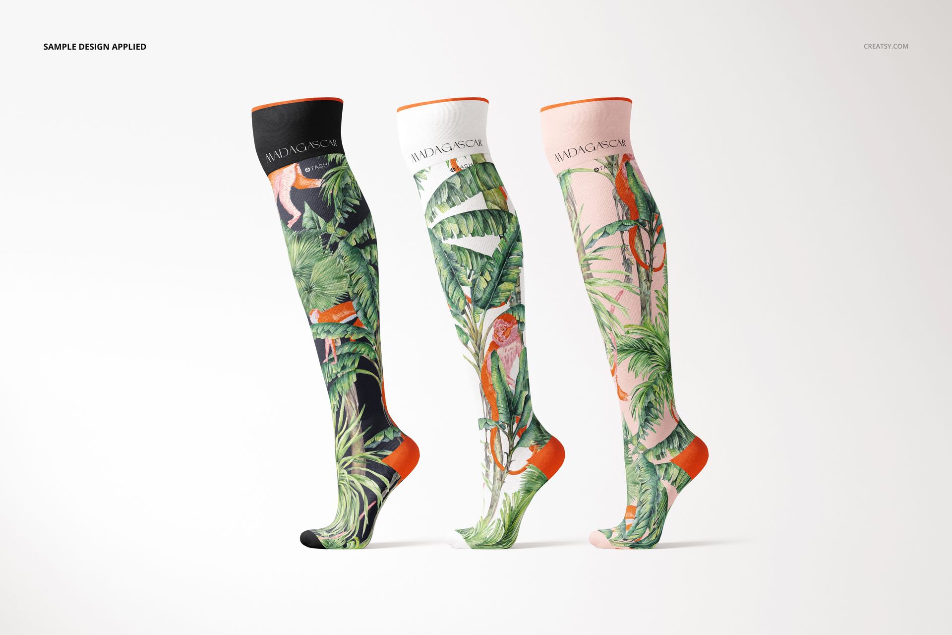 Front view of three knee high socks mockup featuring vibrant green foliage and animal prints, isolated on white.