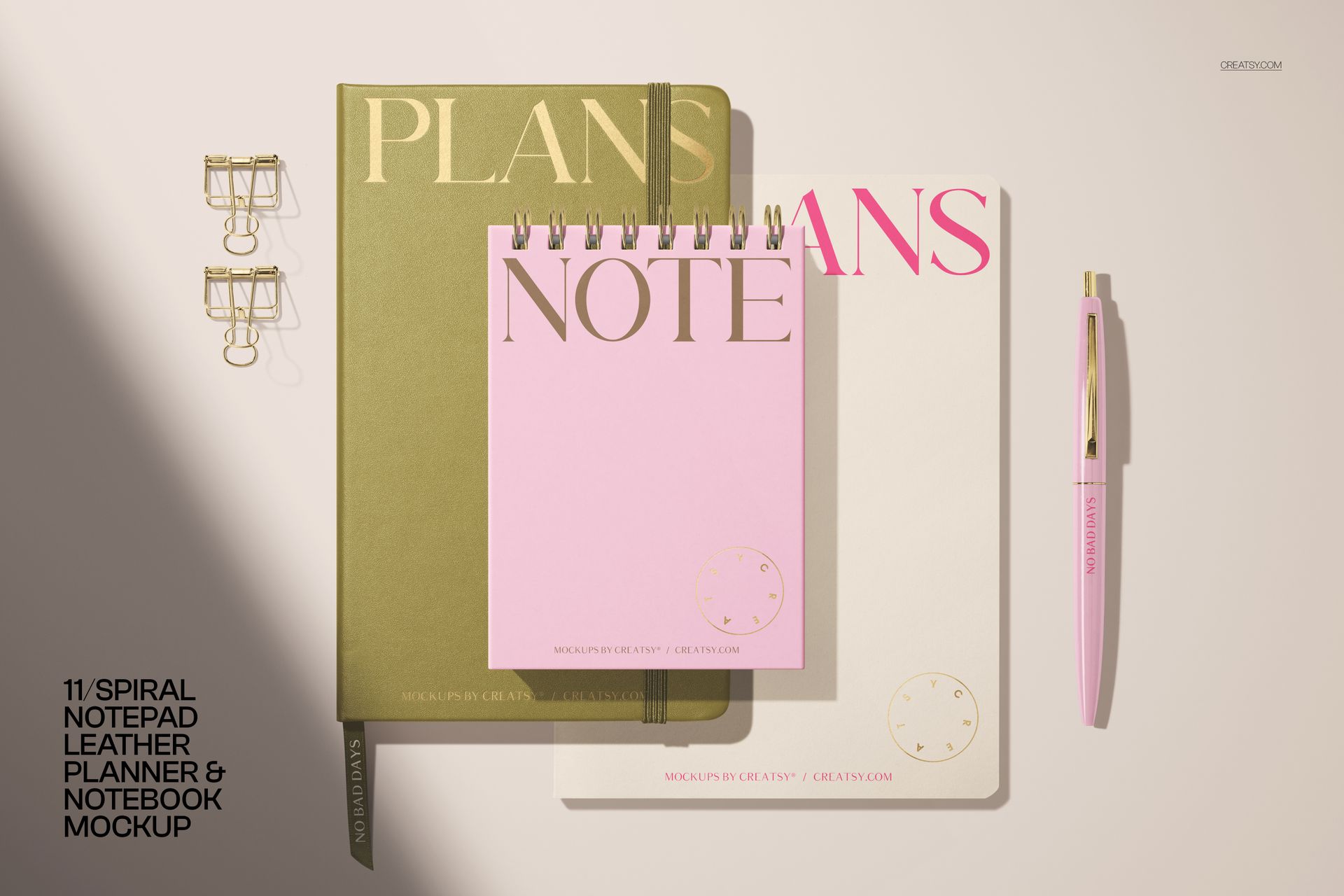 PSD mockup of a stationery set including a pink spiral notepad, green planner, white notebook, and matching pen.