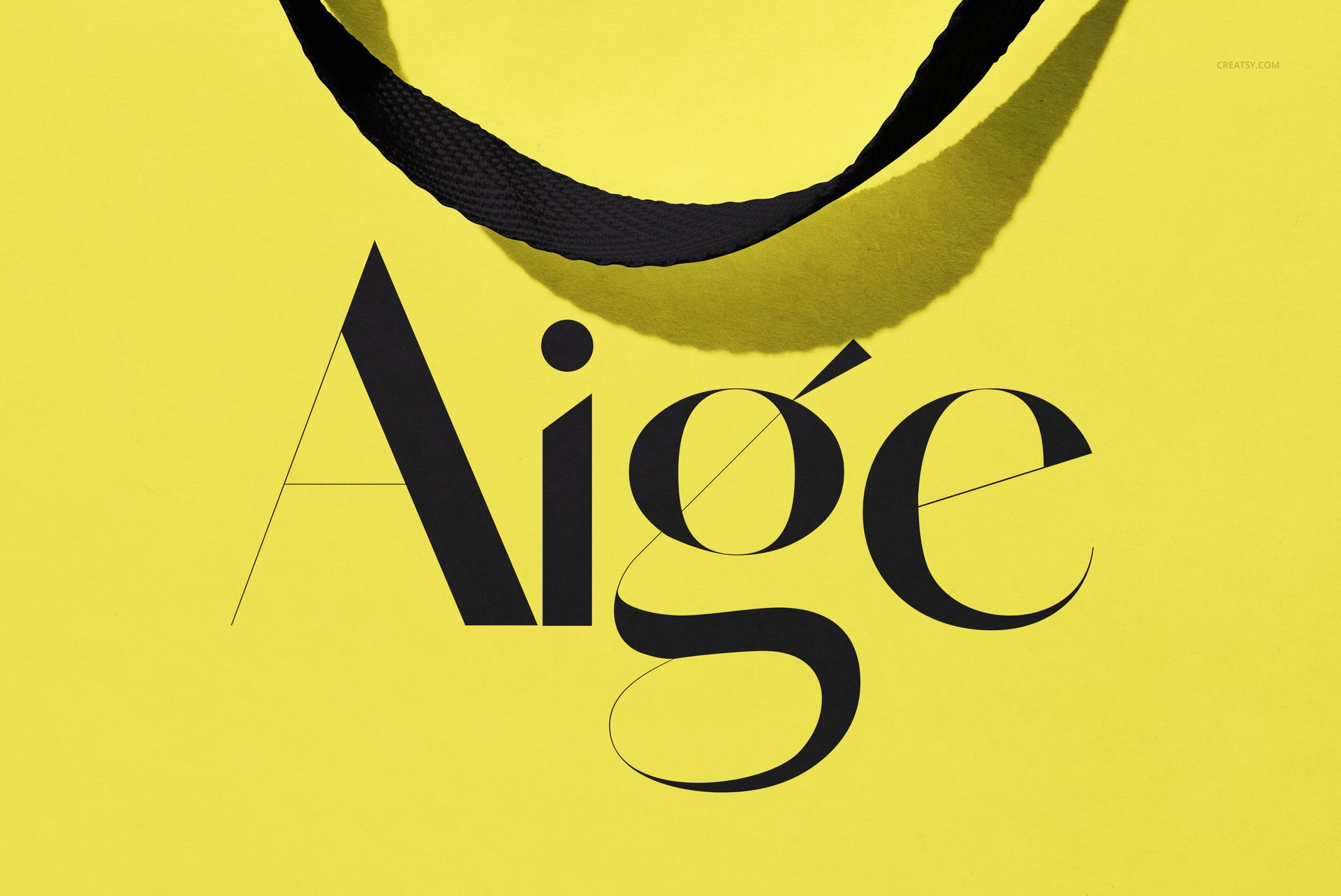 Yellow paper gift bag mockup featuring a black ribbon handle and large black text design, shown from above.