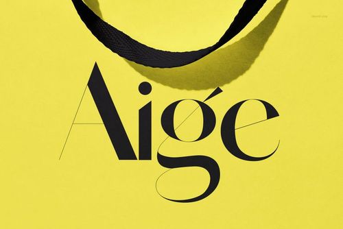 Yellow paper gift bag mockup featuring a black ribbon handle and large black text design, shown from above.