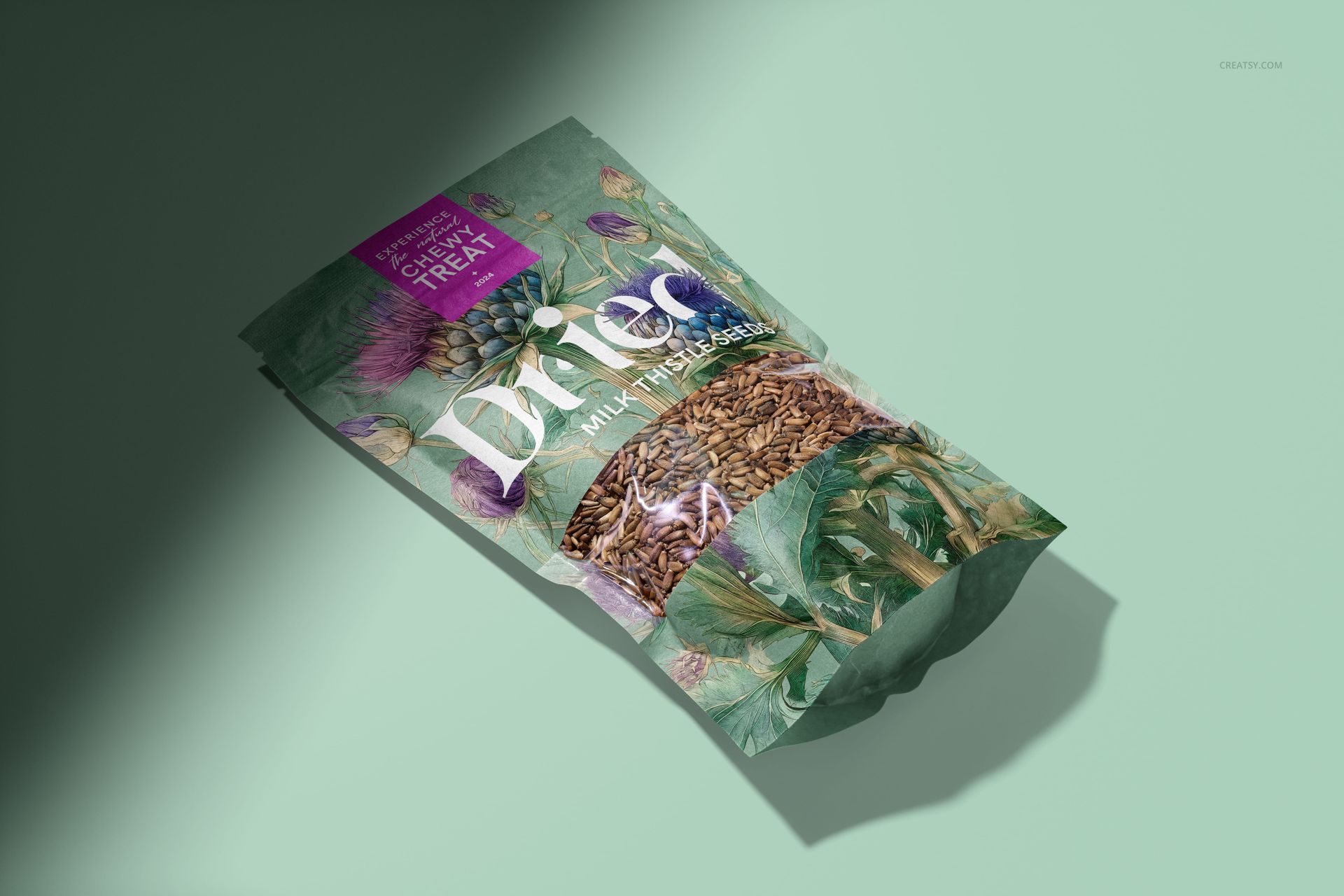 Standing paper pouch mockup with visible milk thistle seeds, floral artwork, and clear section, displayed on light green surface.