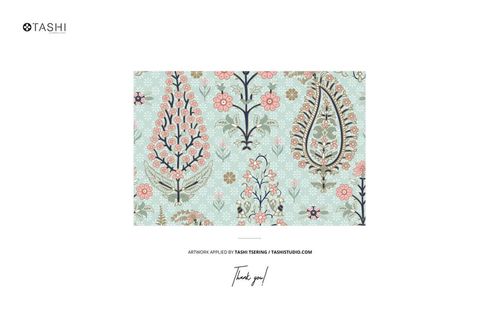 Cotton fabric swatch mockup displayed at an angle with intricate floral and paisley designs in soft colors.