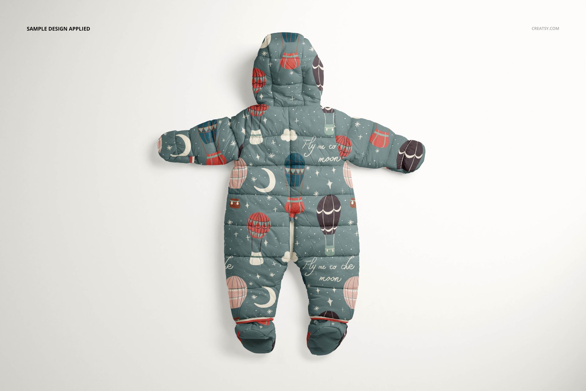 Front view of a baby snowsuit mockup with a whimsical hot air balloon and moon pattern on a muted blue background.
