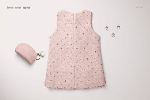 Sleeveless baby dress mockup in pale pink with small red floral pattern, displayed flat on a light background.