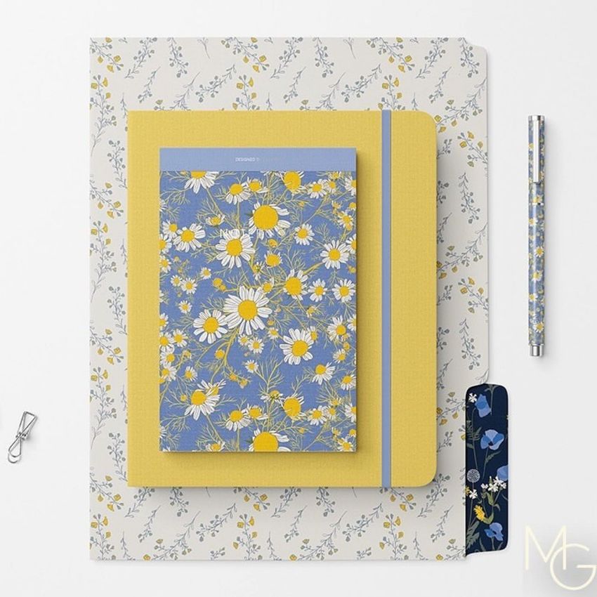 Stationery set mockup featuring a notebook, notepad, and pen with chamomile flower patterns in yellow, blue, and white.