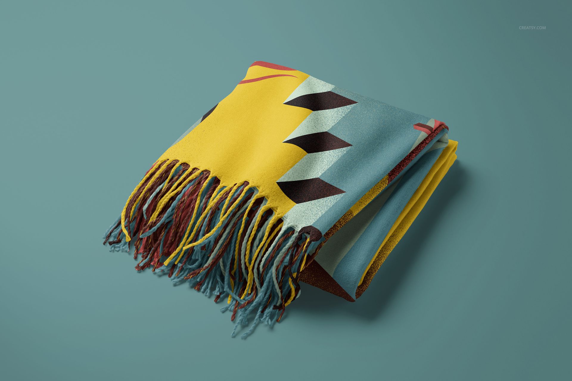 Tassel fringe blanket mockup featuring yellow, blue, and brown geometric design, shown folded on a teal background.