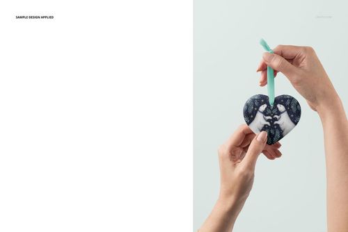 PSD mockup of a handmade heart-shaped Christmas ornament with a blue and white pattern, held by hands.