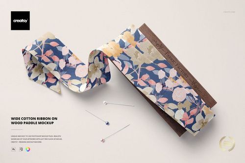 PSD mockup featuring wide patterned cotton ribbon on a wood paddle, surrounded by three sewing pins on a light background.