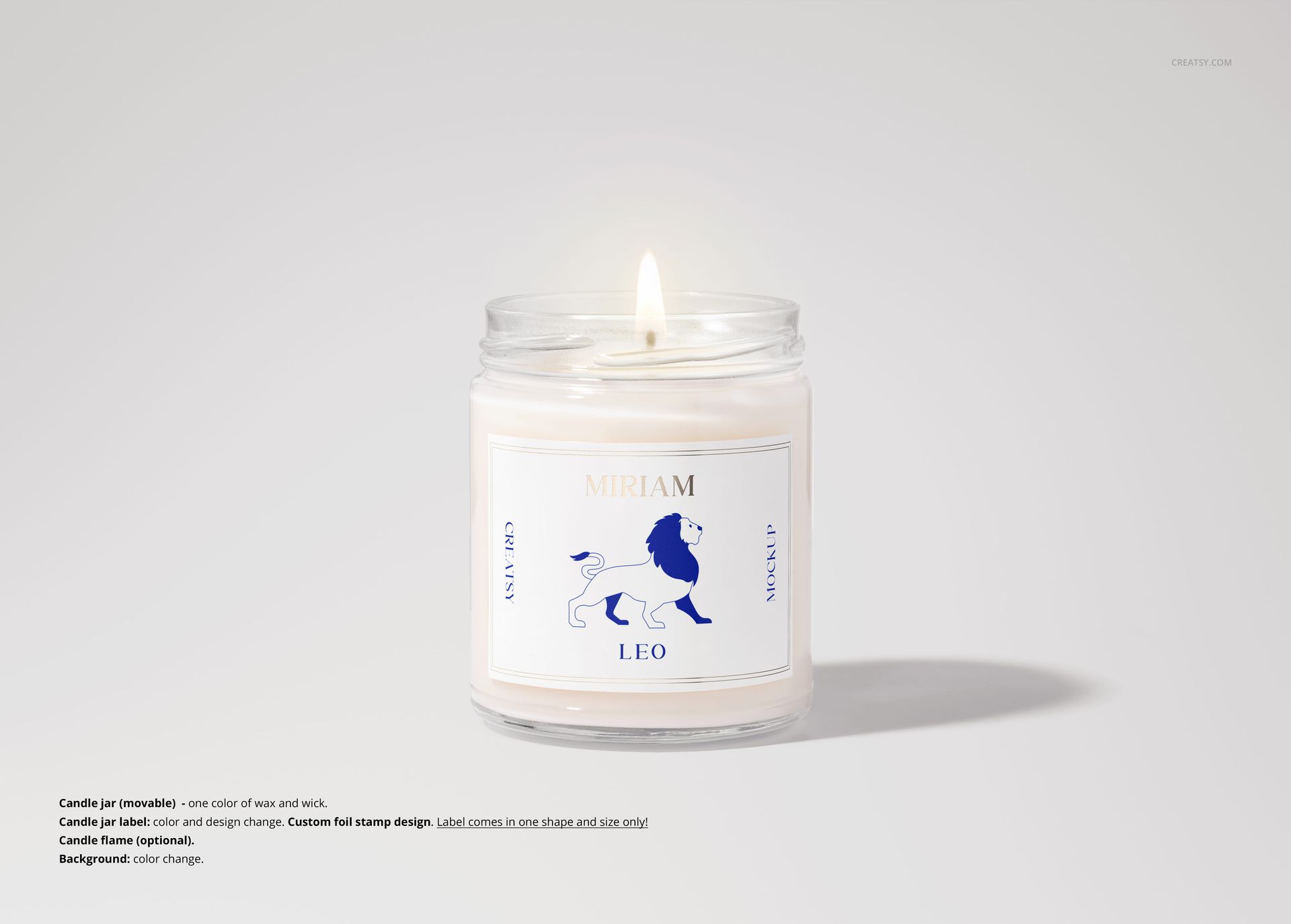 Scented soy candle mockup in a transparent jar, white wax, blue and white label, and soft shadows on a neutral surface.
