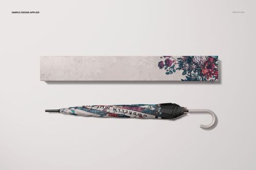 Umbrella packaging mockup featuring a closed umbrella and decorative box with botanical motifs, top perspective.