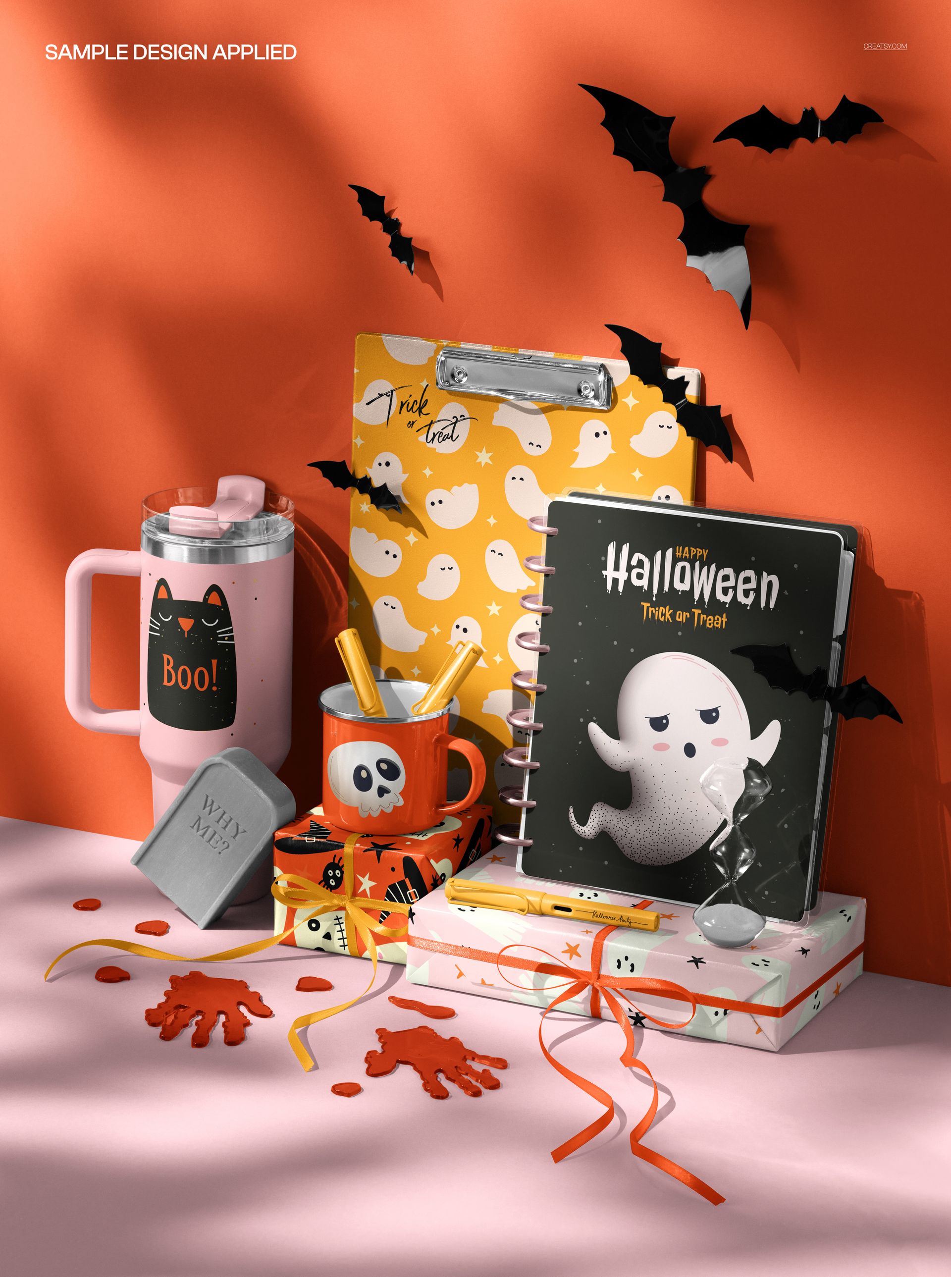 Front view of Halloween desk mockup with notebooks, mugs, clipboard, and bat decorations in festive colors.