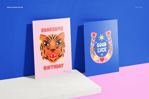A5 cards mockup featuring a pink birthday card with a tiger graphic and a blue good luck card with a horseshoe motif.