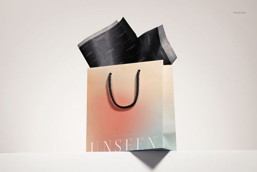 PSD mockup featuring a pastel-toned gift bag with dark tissue paper peeking out, set against a neutral background.