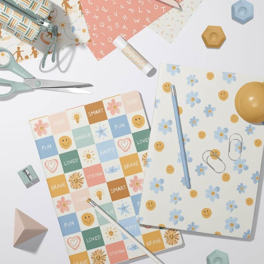 Stationery mockup showing two classic A4 notebooks on a white surface, surrounded by pastel office supplies and patterned papers.