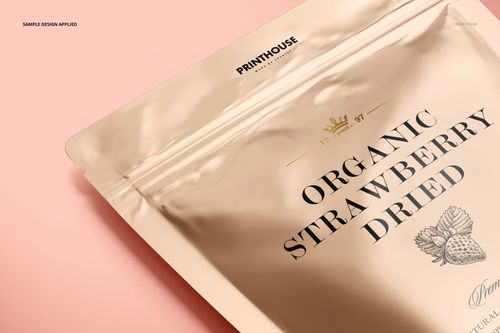 Front view of a metallic zip lock pouch mockup featuring bold black text and a strawberry graphic on a pink surface.