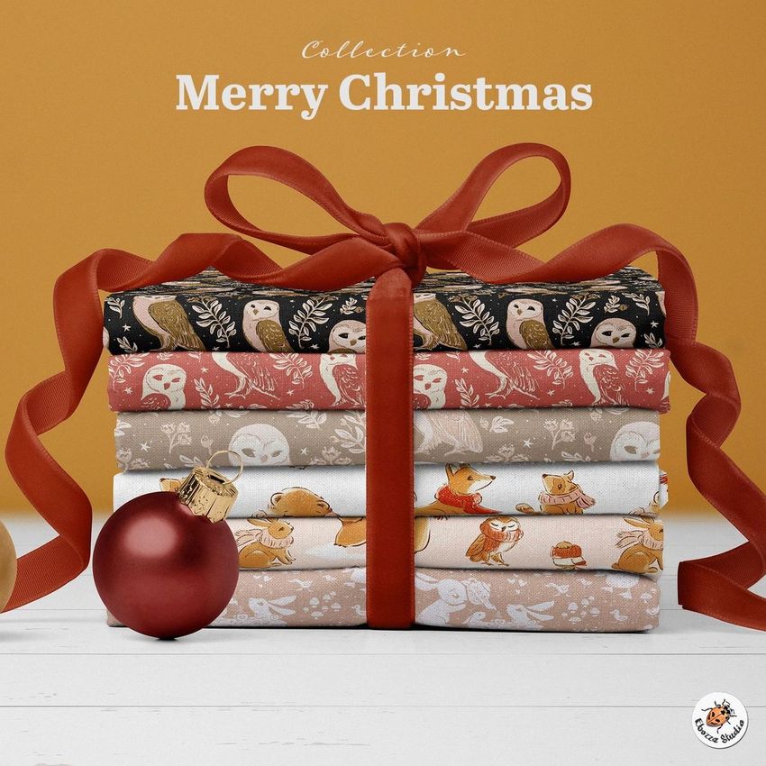 Fabric stack mockup featuring folded Christmas-themed textiles with animal patterns, tied with a red ribbon and baubles on a white surface.