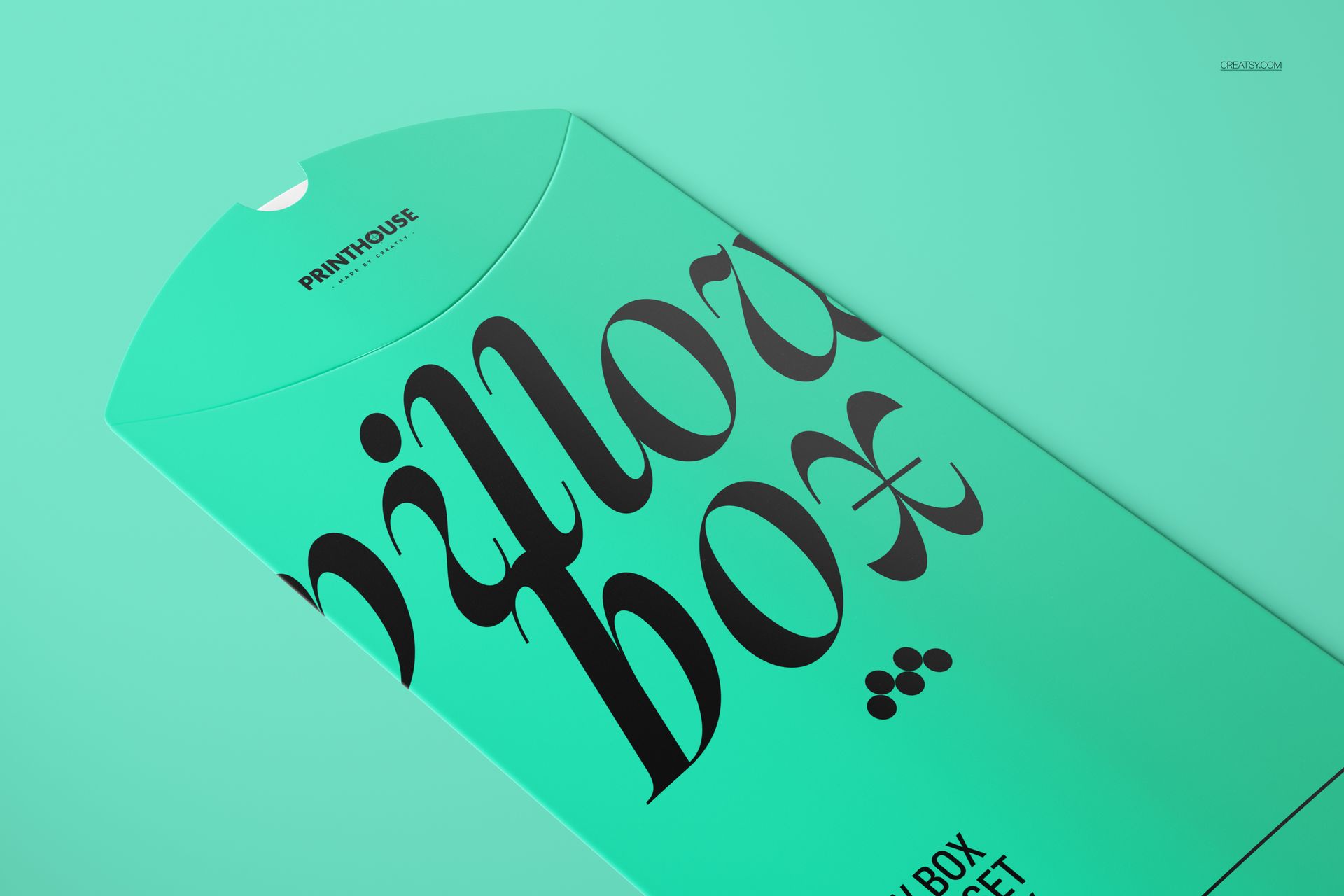 Close-up of a turquoise pillow box mockup featuring large black lettering and a simple, solid color background.