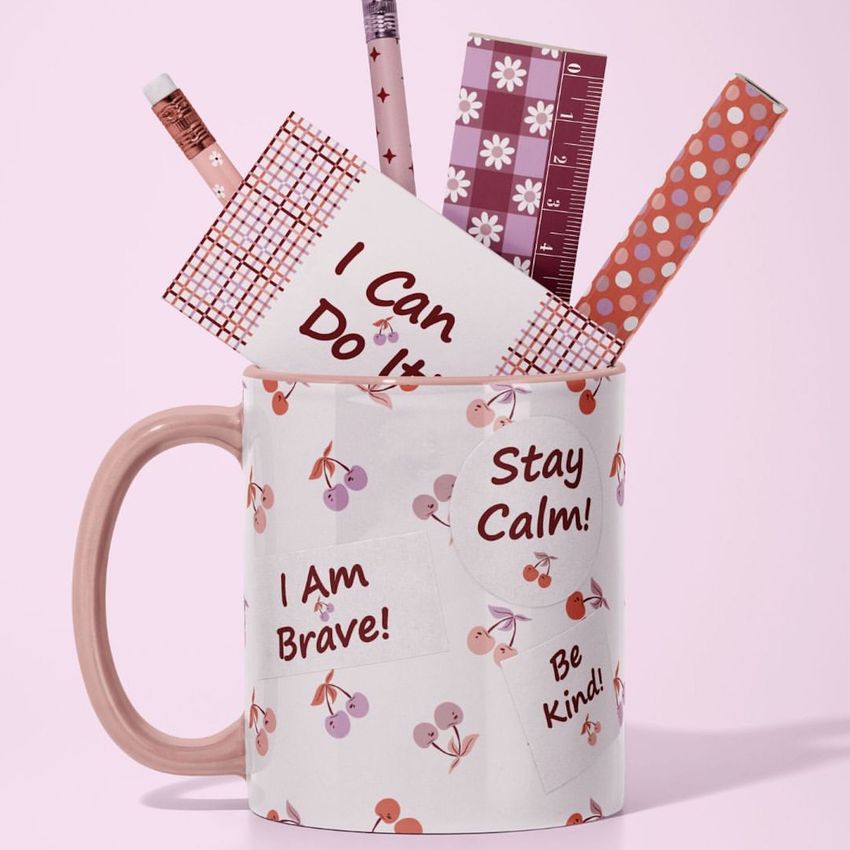 Mug mockup filled with various office supplies like pencils, rulers, and pens, featuring a cherry pattern and motivational text.