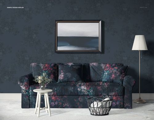 Skirted sofa mockup with floral upholstery and pillows, placed before a dark wallpaper and framed artwork.