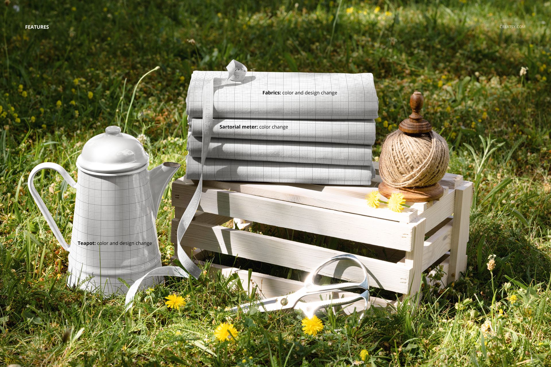 PSD mockup featuring several folded fabrics with a grid design placed on a white crate outdoors in the grass.