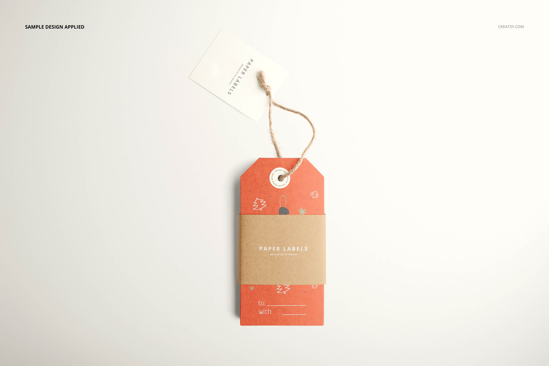 Top view of paper labels mockup, showing a red patterned tag with a brown band and a white label in the background.