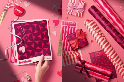Valentine's Day packaging mockup featuring pink and red patterned wrapping paper, gift boxes, and decorative props on a pink surface.